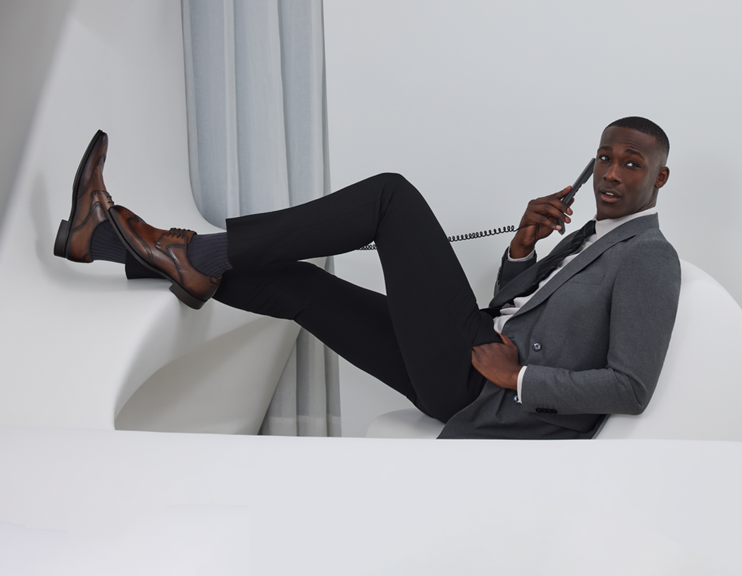 Modelo con traje gris y zapatos de vestir en una campaña de Mezlan